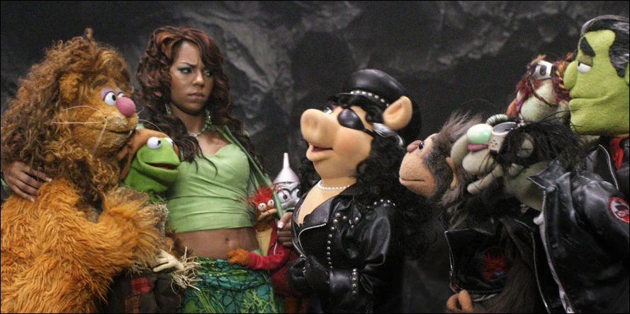 screenshot from 'The Muppets' Wizard of Oz' showing Dorothy, Fozzie, Kermit, and Gonzo facing off against Wicked Witch Miss Piggy and her biker henchmen